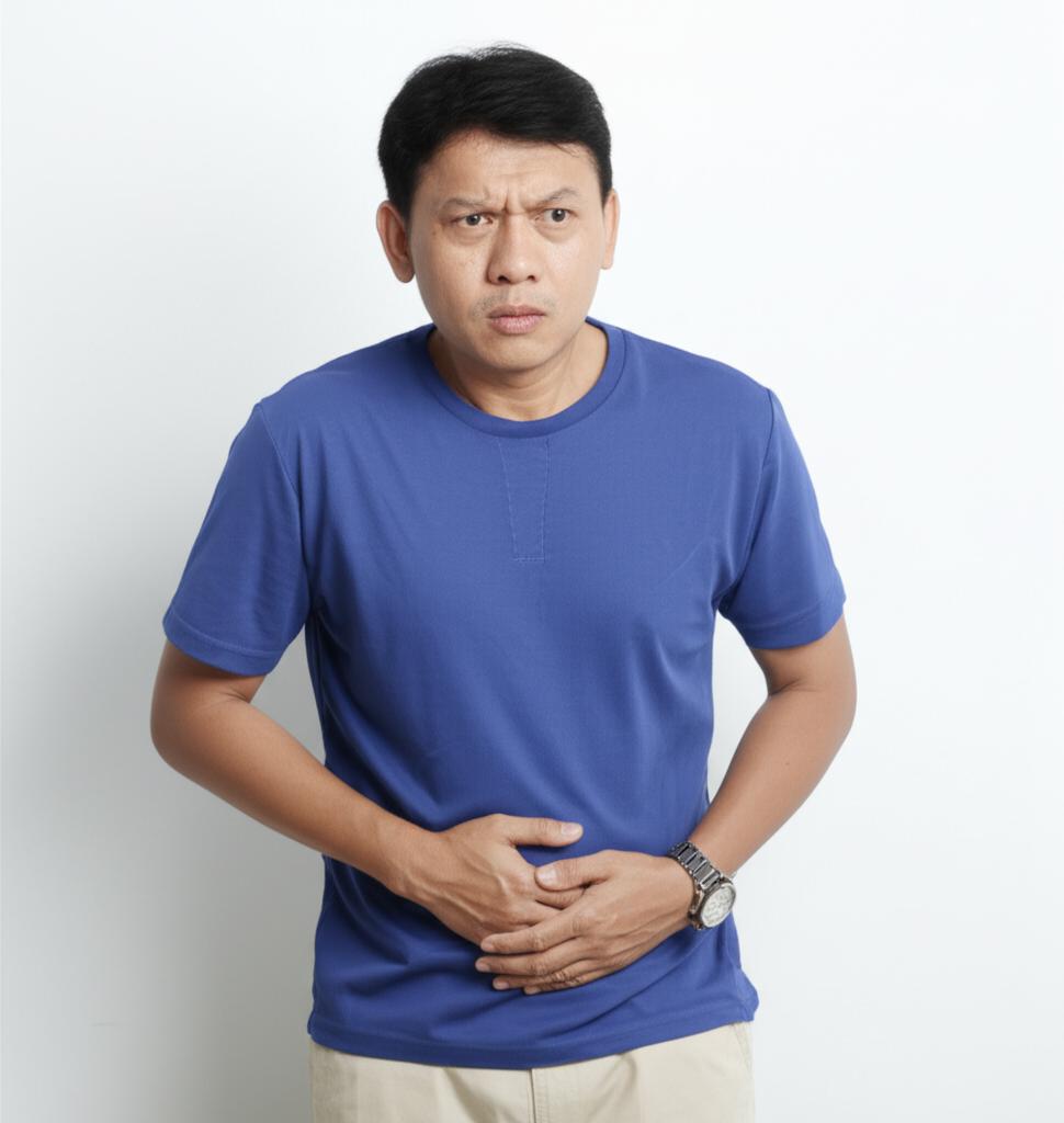 realistic photo of an Indonesian man looking concerned about his health, perhaps holding his lower abdomen or looking thoughtful